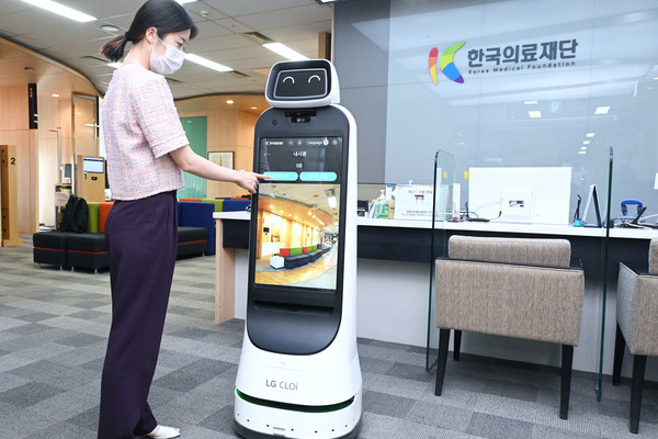 ▲. 한국의료재단 종합검진센터 직원이 LG 클로이 가이드봇을 활용해 건강검진 안내를 받는 모습을 시연하고 있다.