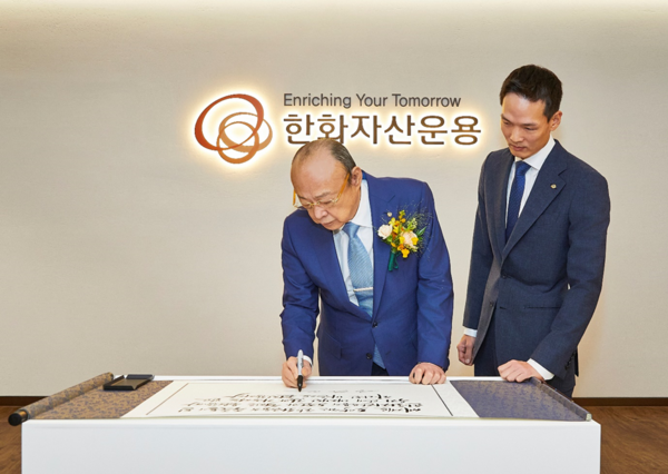 ▲한화그룹 김승연 회장이 한화자산운용 본사를 방문해 임직원을 격려하는 방명록을 작성하고 있다.