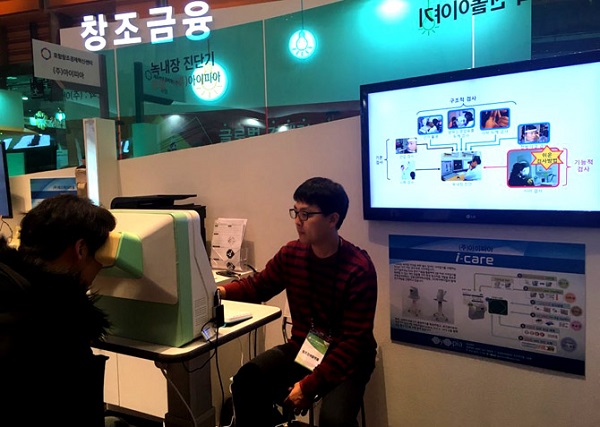 창조경제박람회를 찾은 관람객이 아이피아가 개발한 녹내장 진단기 '아이케어'를 활용해 시야검사를 하고 있다..jpg