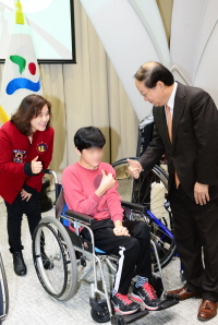 크기변환_(사진자료2)생명보험사회공헌재단 유석쟁 전무가 지하철 건강기부계단에서 적립된 기부금으로 장애아동 보행 보조기구를 전달하고 있다.jpg