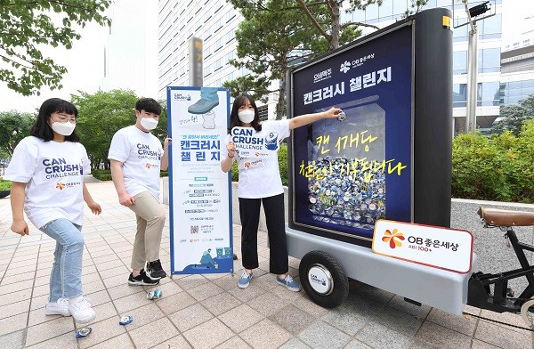 ▲오비맥주 직원들이 강남구 삼성동 본사 앞에서 알루미늄 캔의 올바른 분리배출법을 알리는 캔크러시 챌린지 캠페인에 참여하고 있다.
