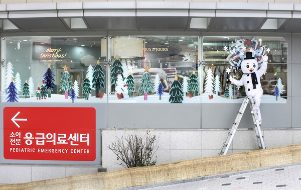 ▲ CJ푸드빌이 운영하는 뚜레쥬르가 10일 오전 서울 종로구 대학로에 위치한 서울대학교병원 어린이병원에서 작가 나난의 윈도우 페인팅 퍼포먼스를 선보이고 있다.