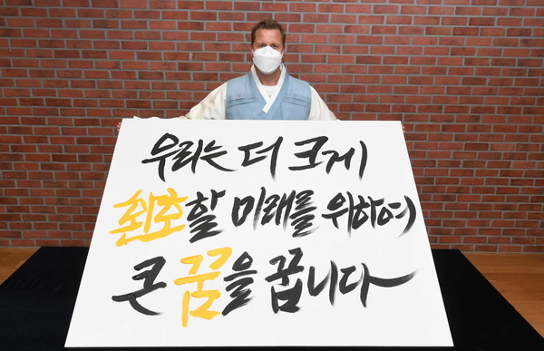 ▲지난 26일 오비맥주 배하준 대표가 새로운 기업 슬로건을 공개하는 선포식에서 새 슬로건 캘리그래피 작품을 들고 기념 촬영을 하고 있다