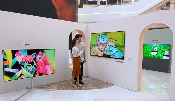 ▲LG전자 모델들이 전시관에 전시된 올레드 TV로 구현한 NFT 작품을 구경하고 있다.