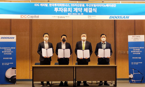 ▲투자유치 계약 체결식이 끝나고, 두산모빌리티이노베이션 이두순 대표(왼쪽 셋째)가 한국투자파트너스 장학성 본부장, IDG캐피탈 이혁진 부사장, DS자산운용 장경배 이사와 기념사진을 촬영하고 있다.