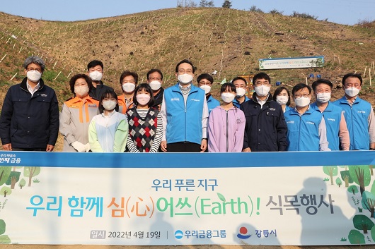 ▲ 손태승(오른쪽에서 여섯번째) 우리금융지주 회장, 이원덕(오른쪽에서 세번째) 우리은행장, 정일섭(오른쪽에서 네번째) 강릉시장 권한대행이 지역주민들, 우리금융 임직원들과 함께 기념촬영을 하고 있다.