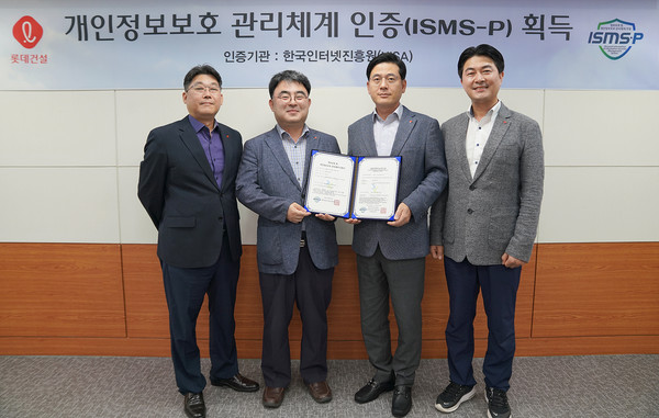 ▲ 롯데건설 정보보호 관계자들이 ISMS-P 인증서를 들고 촬영하고 있다.