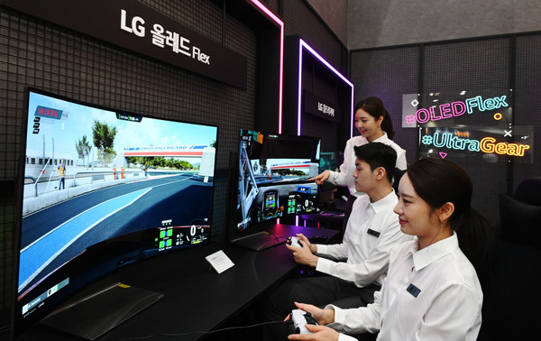 ▲LG전자 모델들이 4일부터 나흘간 서울 삼성동 코엑스에서 열리는 한국전자전(KES 2022)에서 벤더블(Bendable) 게이밍 올레드 TV 플렉스(FLEX)로 게임을 즐기고 있다.