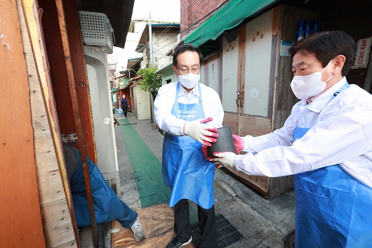 ▲ 손태승 우리금융미래재단 이사장(왼쪽)과 임직원들이 지난 14일 서울 영등포구 쪽방촌을 방문해 연탄을 옮기고 있다.