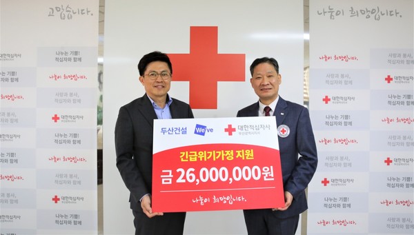 ▲오세욱 두산건설 상무(왼쪽)와 권용규 대한적십자사 부산광역시지사 사무처장이 성금 전달 후 기념 촬영을 하고 있다.