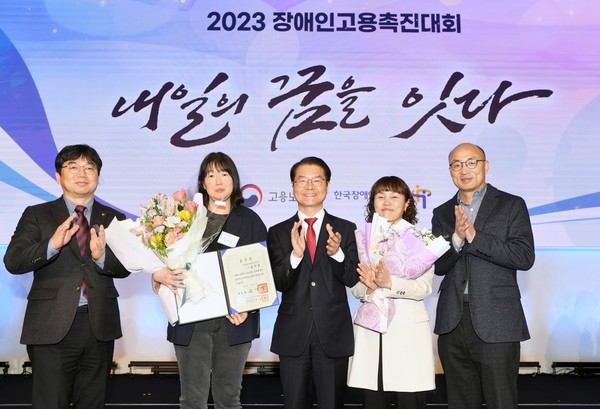 ▲한국동그라미파트너스 김미영 사원(왼쪽에서 두번째), 이정식 고용노동부 장관(가운데) 등이 시상식에서 기념촬영을 하고 있다.