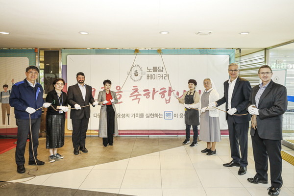 ▲GM은 18일 부평 본사 홍보관에서 장애인 바리스타가 운영하는 노틀담베이커리를 오픈했다. 사진은 (맨 오른쪽에서 두번째) GM 한국사업장 로베르토 렘펠 사장, (맨 오른쪽) 연구개발법인 브라이언 맥머레이 사장을 비롯, 회사 및 노틀담베이커리 관계자들이 카페 오픈식을 맞아 언베일링 세리머니를 하고 있는 모습.