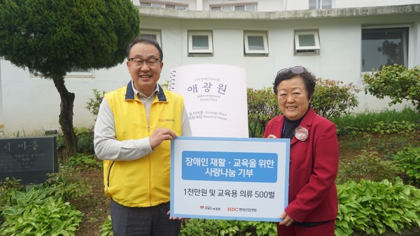 ▲ 신왕섭 HDC현대산업개발 실장(왼쪽)과 송우정 거제도 애광원 대표가 장애인을 위한 재활 지원 성금과 교육용 의류를 전달하고 기념 촬영을 하고 있다.