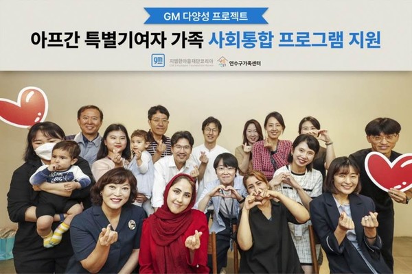 ▲26일 인천시 부평 한국지엠 본사 홍보관에서 열린 행사에 참석한 주영신 연수구가족센터장(맨 앞 왼쪽), 아프간 특별 기여자 사자디 마르지아씨, 호싸니 파티마씨(맨 앞 가운데 왼쪽부터), 염지연 지엠한마음재단코리아 사무국장(맨 앞 오른쪽) 및 GM 임직원들이 단체사진을 촬영하고 있다.