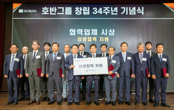 ▲ 김선규 호반그룹 회장(앞줄 가운데)이 협력사 관계자들에게 지원금을 전달하고 기념 촬영을 하고 있다.