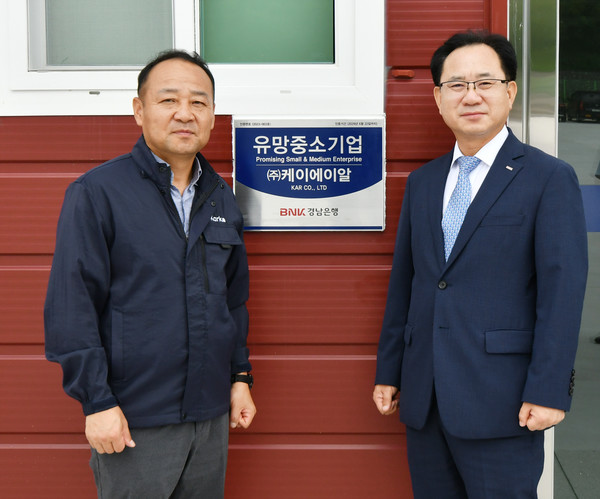 ▲BNK경남은행 이상봉 부행장(사진 오른쪽)과 ㈜케이에이알 최성재 대표가 ‘유망중소기업 현판식’을 갖고 있다.