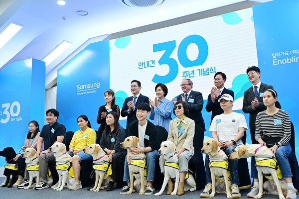 ▲용인 삼성화재 안내견학교에서 새롭게 활동을 시작하는 안내견들과 시각장애인 파트너, 관계자들이 기념 촬영을 하고 있다.
