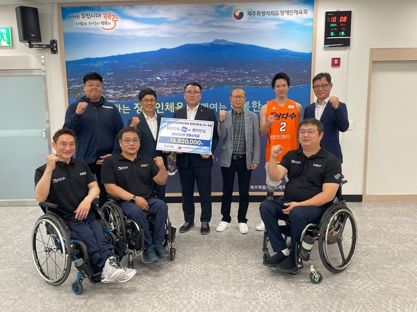 ▲ 오세욱 두산건설 상무(윗줄 왼쪽에서 2번째), 정재훈 제주특별자치도장애인체육회 상임부회장(윗줄 왼쪽에서 3번째)과 제주삼다수휠체어농구단 선수들이 기념 사진 촬영을 하고 있다.