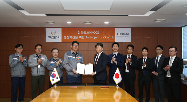 한화오션 조선소장 이길섭 부사장(왼쪽에서 네번째)이 교세라의 마츠나가 카즈히로 사업부장(왼쪽에서 다섯번째)과 계약서에 서명하고 기념 촬영을 하고 있다.