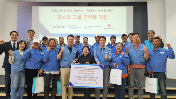 포스코 노사 관계자들이 몽골 자르갈란트 지역 목축농가 주민들에게 포스코 구형 근무복을 전달하고 기념사진을 찍고 있다.