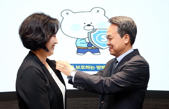 ▲ 진옥동 신한금융지주 회장(오른쪽)이 박현주 신한금융지주 소비자보호파트장(부사장)에게 소비자보호 뱃지를 달아주고 있다.