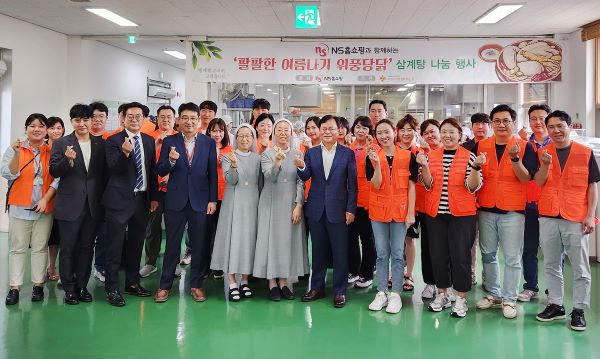 ▲NS홈쇼핑 조항목 대표이사(오른쪽에서 다섯번째)와 임직원 자원봉사자들이 삼계탕 나눔 행사에 참여해 기념 촬영을 하고 있다