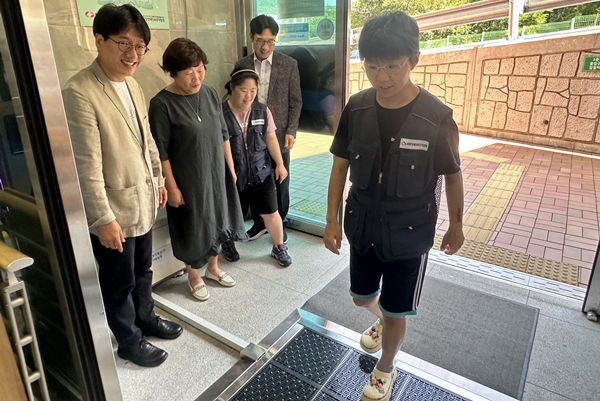 ▲희망장애인보호작업장 출입구에서 작업장 근로자가 미세먼지 자동 흡입 기기를 이용하는 모습