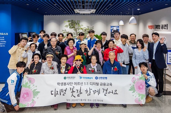 ▲ 신한 학이재 디지털 금융교육 어시스턴트와 교육을 수강한 고령층 고객이 기념촬영을 하고 있다.