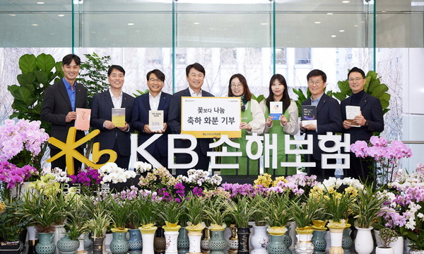 ▲KB손해보험 구본욱 대표(왼쪽에서 네 번째)가 화분과 도서를 기부하며 기념사진을 촬영하고 있다