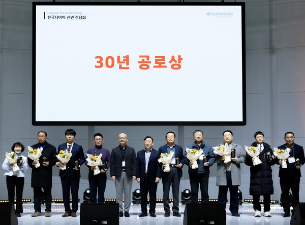 ▲(왼쪽 다섯 번째부터) 이상훈 한국타이어앤테크놀로지 사장, 이용관 한국사업본부장 전무가 30년 공로상을 수상한 딜러사 관계자들과 기념 촬영을 하고 있다.