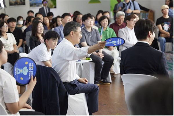 ▲김동연 도지사가 지난달 30일 시흥에코센터에서 진행된 '경기도 기후도민총회 출범식'에서 도민 참가자에게 부채질을 해주고 있다