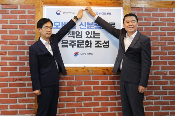 ▲지난 14일 하이트진로 김인규 대표(오른쪽)와 행정안전부 김민재 차관이 행정안전부가 지정한 서울 서초동 하이트진로 본사 인근 착한가격업소를 방문해 모바일 신분증 활용을 권장하는 홍보 포스터를 부착했다.