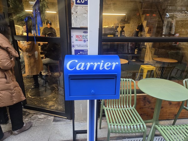 ▲‘캐리인더시티’ 참여 매장 앞에 캐리어 로고가 새겨진 우편함이 놓여져 있다.